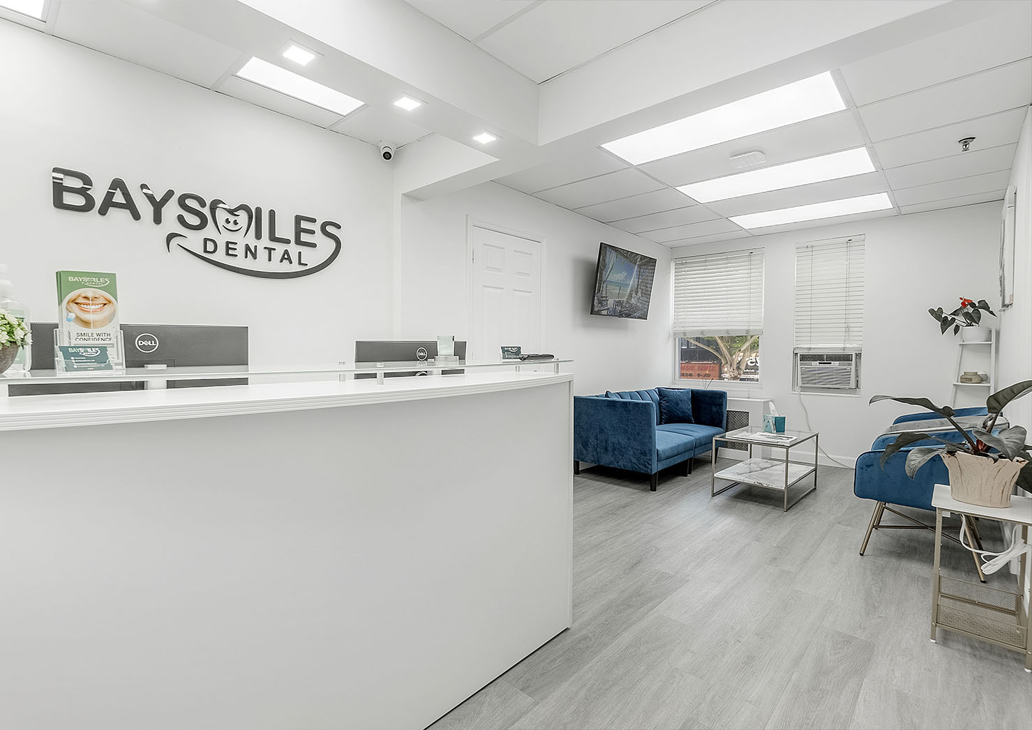 The image shows an interior view of a dental office reception area, featuring a modern design with a clean and bright atmosphere.