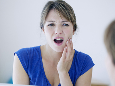 A woman with a surprised expression, holding her hand to her mouth.